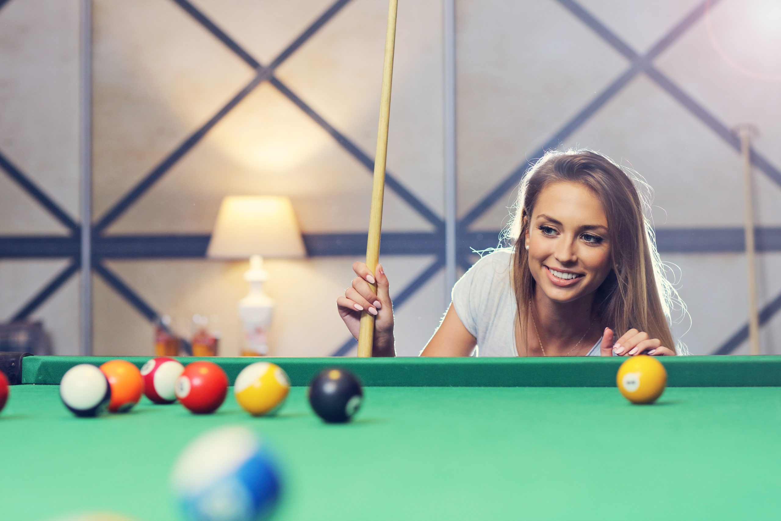 Picture of pretty woman playing billards in a billiards bar restaurant lounge. Free demo download of billiards pos software.